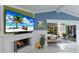 Fireplace with a TV, flanked by plants, and views of the outdoor living area and pool at 3408 Brookridge Ln, Parrish, FL 34219