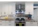 Modern kitchen featuring a stainless steel range hood, updated appliances, and granite countertops at 3408 Brookridge Ln, Parrish, FL 34219