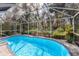 Inviting screened-in pool area surrounded by lush landscaping, perfect for outdoor enjoyment and privacy at 3408 Brookridge Ln, Parrish, FL 34219