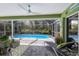 Relaxing screened-in pool area with comfortable lounge chairs and lush tropical landscaping at 3408 Brookridge Ln, Parrish, FL 34219