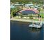 Aerial view of a waterfront home with a boat dock, solar panels, and a screened-in patio at 3572 Peace River Dr, Punta Gorda, FL 33983