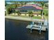 A waterfront house featuring solar panels, a screened lanai, and boat dock with a boat lift at 3572 Peace River Dr, Punta Gorda, FL 33983