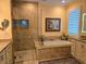 Luxurious bathroom with a soaking tub, glass enclosed shower, and granite countertops at 3572 Peace River Dr, Punta Gorda, FL 33983