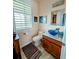Charming bathroom featuring a granite vanity, vessel sink, and shuttered window offering natural light and privacy at 3572 Peace River Dr, Punta Gorda, FL 33983