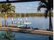 Dock featuring a boat lift, surrounded by water views with palm trees, enhancing the property's appeal at 3572 Peace River Dr, Punta Gorda, FL 33983