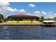 Waterfront home with a screened lanai, a red metal roof, and direct access to the water and boat dock at 3572 Peace River Dr, Punta Gorda, FL 33983