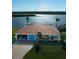 Aerial view of a charming waterfront home with an attached garage, and tropical landscaping at 3572 Peace River Dr, Punta Gorda, FL 33983