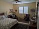 Comfortable bedroom featuring a ceiling fan, plantation shutters, and elegant furnishings at 3572 Peace River Dr, Punta Gorda, FL 33983