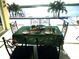 Outdoor breakfast and dining area overlooks the tranquil waterscape with lush palm trees under a sunny sky at 3572 Peace River Dr, Punta Gorda, FL 33983
