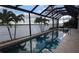 Screened outdoor pool offers stunning water views framed by tropical palm trees, creating a serene retreat at 3572 Peace River Dr, Punta Gorda, FL 33983
