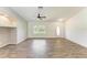 Bright living room with wood-look tile, a ceiling fan, and easy access to other areas of the home at 3749 Albatros Ln, North Port, FL 34288