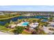 Aerial view of a community pool, playground, lake, and surrounding homes on a sunny day at 3838 Manorwood Loop, Parrish, FL 34219