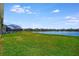 Manicured back lawn with beautiful lake view, pool, and screened enclosure at 3838 Manorwood Loop, Parrish, FL 34219
