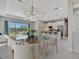 Open concept dining area with modern chandelier and view into the kitchen, next to large windows at 3838 Manorwood Loop, Parrish, FL 34219