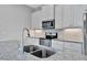 Close up on modern kitchen with granite countertops, stainless steel appliances, and sink at 3838 Manorwood Loop, Parrish, FL 34219