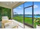 Screened-in patio offers lake views and outdoor seating area, with manicured lawn and lush landscaping at 3838 Manorwood Loop, Parrish, FL 34219