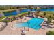 Aerial view of a community pool with lounge chairs, umbrellas, and a slide near the pool at 3838 Manorwood Loop, Parrish, FL 34219