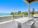 Relax on this expansive balcony with ocean views and comfortable seating, perfect for outdoor dining at 3909 Casey Key Rd, Nokomis, FL 34275