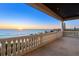 Outdoor balcony with ocean views and decorative railings overlooking the shoreline at sunset at 3909 Casey Key Rd, Nokomis, FL 34275