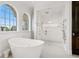 Bright bathroom featuring a modern tub, walk-in shower and multiple arched windows for ample natural light at 3909 Casey Key Rd, Nokomis, FL 34275
