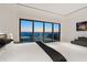 Bright main bedroom with sliding glass doors, ocean view, and minimalist modern design at 3909 Casey Key Rd, Nokomis, FL 34275