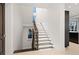 Well-lit staircase with wooden handrail and treads, leading to the upper levels of the home at 3909 Casey Key Rd, Nokomis, FL 34275