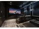 Home theater room with a large screen, black leather recliners, and plush carpet at 3909 Casey Key Rd, Nokomis, FL 34275