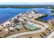 Aerial view of a beautiful coastal community with a pier, sandy beach, tennis and basketball courts, and scenic waterfront views at 392 Yeager St, Port Charlotte, FL 33954