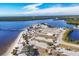 An aerial view showcases a scenic waterfront community with a sandy beach, long pier and ample parking at 392 Yeager St, Port Charlotte, FL 33954