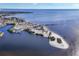 Overhead shot of a coastal community with a pier, sandy beach, boat docks, and neighborhood of waterfront residential homes at 392 Yeager St, Port Charlotte, FL 33954