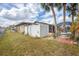 Expansive back yard featuring a privacy fence, green grass and tropical trees at 392 Yeager St, Port Charlotte, FL 33954