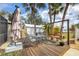 Charming backyard with a wooden deck, swing set, and tropical landscaping at 392 Yeager St, Port Charlotte, FL 33954