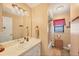 Well-lit bathroom featuring a vanity with a mirror, and a shower and tub with a curtain at 392 Yeager St, Port Charlotte, FL 33954