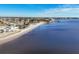 Scenic view of a sandy beach along a calm bay, lined with waterfront homes and lush landscaping in a residential neighborhood at 392 Yeager St, Port Charlotte, FL 33954