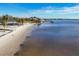 Picturesque shoreline with calm waters, sandy beach, and residential homes with docks, offering a tranquil coastal living experience at 392 Yeager St, Port Charlotte, FL 33954