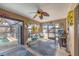 Enclosed Florida room with ceiling fan, cozy seating, and a screened-in view of the pool at 392 Yeager St, Port Charlotte, FL 33954