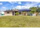 Charming single-story home featuring solar panels, a well-manicured lawn, and a decorative cannon on the front lawn at 392 Yeager St, Port Charlotte, FL 33954