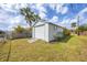 An exterior view of a detached outbuilding with white siding and roll-up door at 392 Yeager St, Port Charlotte, FL 33954