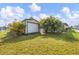 Exterior view of an outbuilding, with a roll-up door and tropical landscaping at 392 Yeager St, Port Charlotte, FL 33954