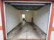 Spacious garage with bare concrete floors and white painted walls with overhead lighting at 3958 Mediterranea Cir # 411, Sarasota, FL 34233