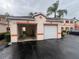 Detached garages with white doors and peach accents, adding curb appeal to the property at 3958 Mediterranea Cir # 411, Sarasota, FL 34233