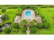 Aerial view of community pool with lounge chairs, tables, palm trees, and lush landscaping at 4141 Entrada Ct, Sarasota, FL 34238