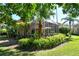Expansive backyard featuring a screened-in patio, lush landscaping, and mature palm trees at 4141 Entrada Ct, Sarasota, FL 34238