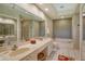 Bathroom featuring double sinks, a large mirror, and a separate shower and bathtub at 4141 Entrada Ct, Sarasota, FL 34238