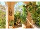 Charming arched entrance, framed with potted plants and lush greenery, leads to a verdant garden at 4141 Entrada Ct, Sarasota, FL 34238