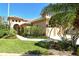 Charming two-story home featuring a tile roof, manicured lawn, and lush tropical landscaping at 4141 Entrada Ct, Sarasota, FL 34238