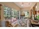 Cozy living room featuring a ceiling fan and sliding doors to screened lanai at 4141 Entrada Ct, Sarasota, FL 34238