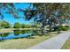 Scenic view of a community pond surrounded by lush landscaping and mature trees at 4141 Entrada Ct, Sarasota, FL 34238