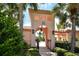 View of community pool area through arched gate, enhanced with landscaping and palm trees at 4141 Entrada Ct, Sarasota, FL 34238