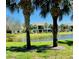 The condo building is set along a lake with a green lawn and palm trees at 4210 Overture Cir # 503, Bradenton, FL 34209